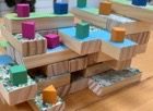stacked wooden blocks with colorful terrain tiles and game pieces